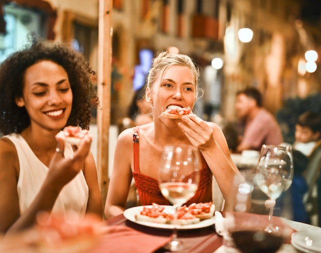 dos mujeres tomando bocadillos nocturnos con bebidas
